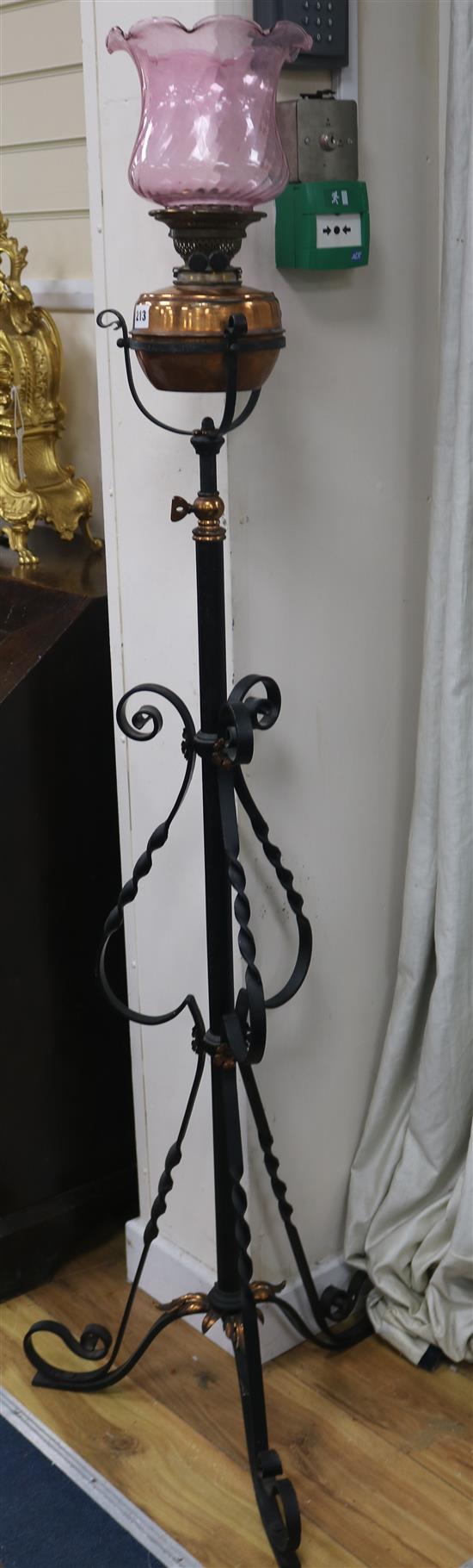 A wrought iron telescopic standard lamp